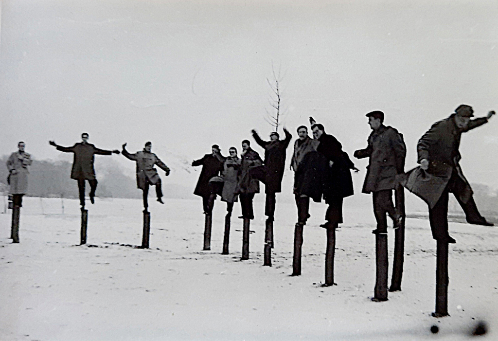 Opiskelijat poseeraavat puupylväiden päässä keikkuen.