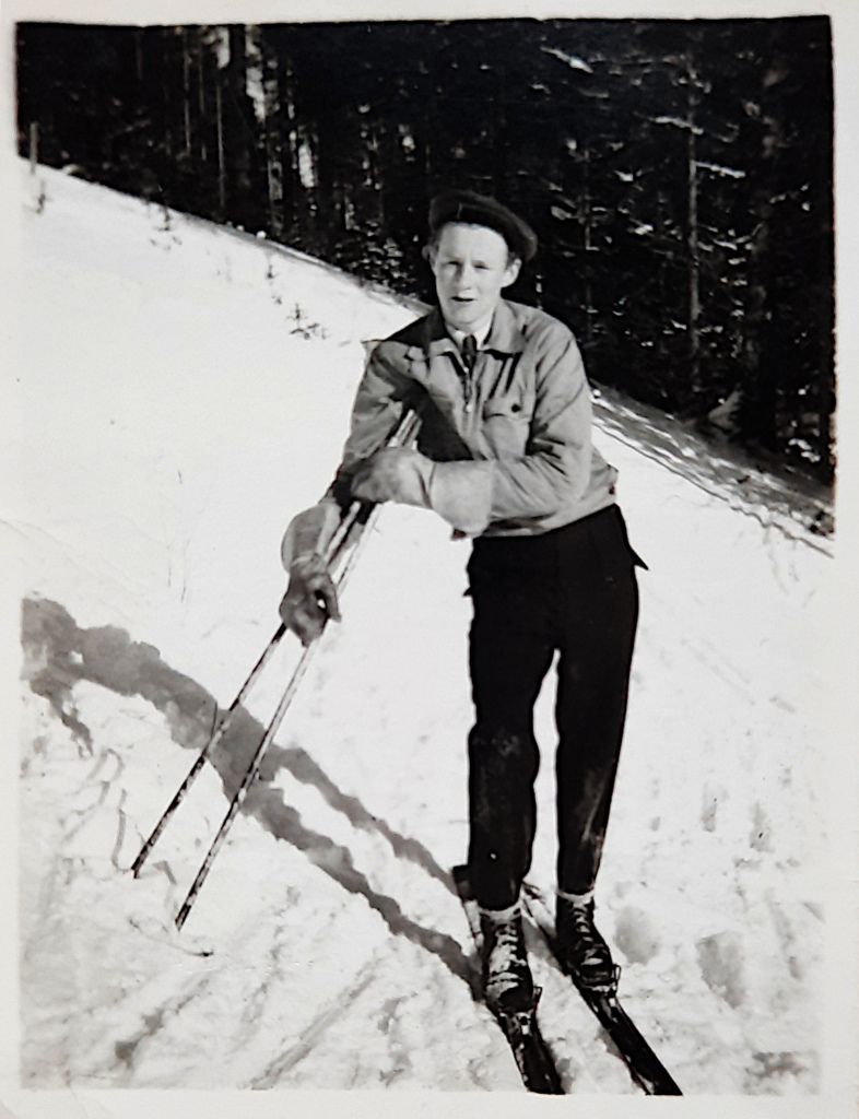 Nuori mies sukset jalassa.