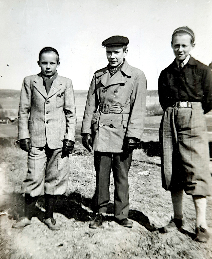 Kolme teinipoikaa asiallisissa vaatteissaan.