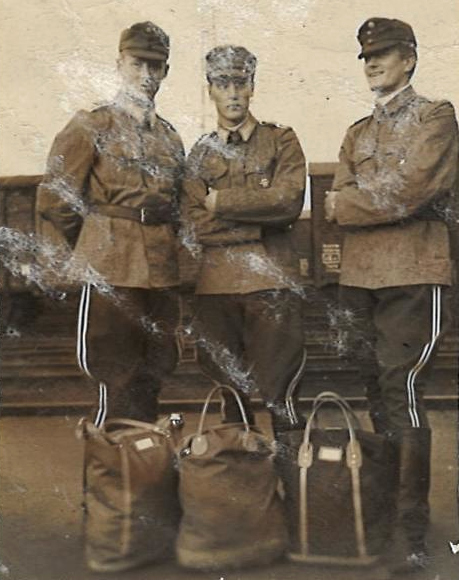 Kolme nuorta miestä sotilasasuissa.