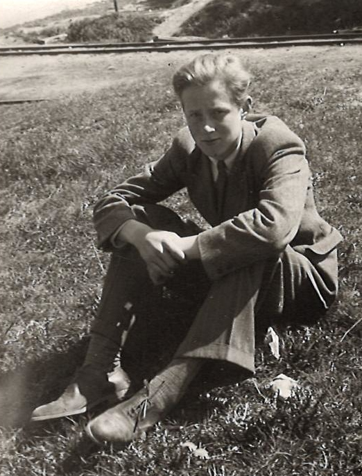 Nuori mies katsoo kameraan.