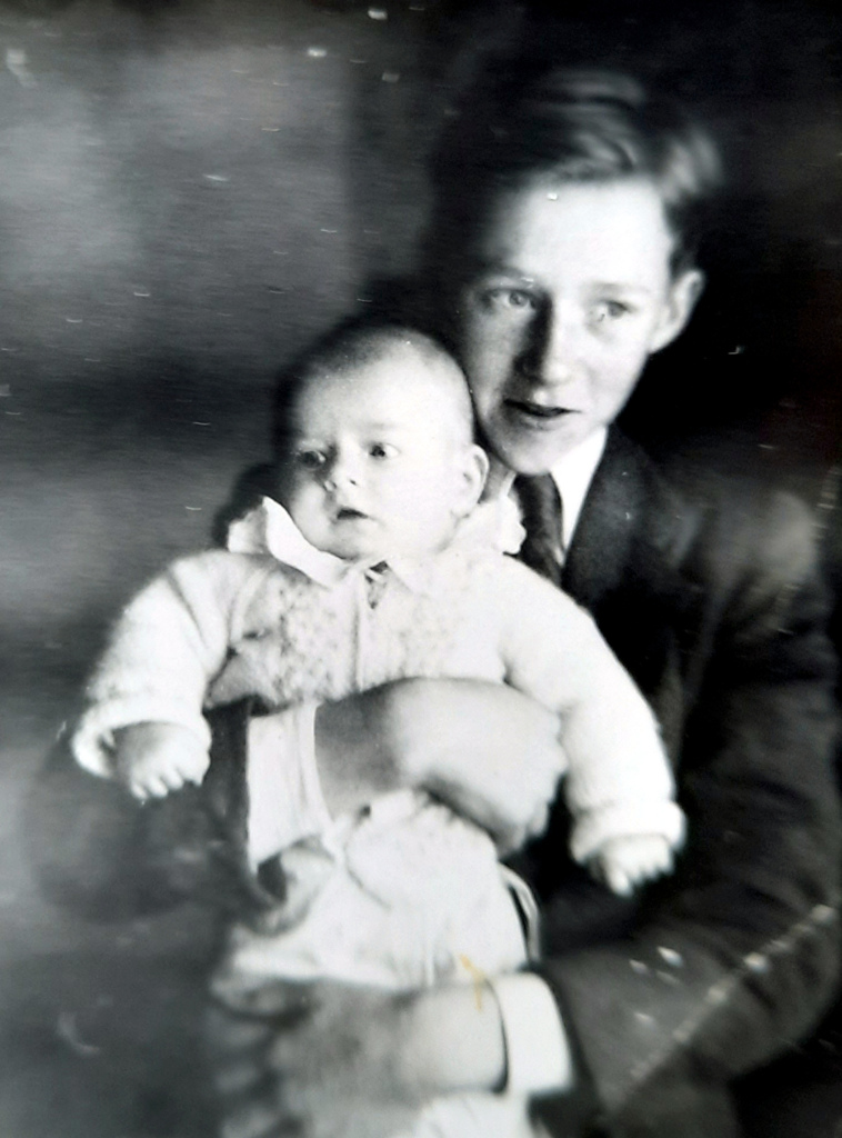 Teinipoika, sylissä vauva.