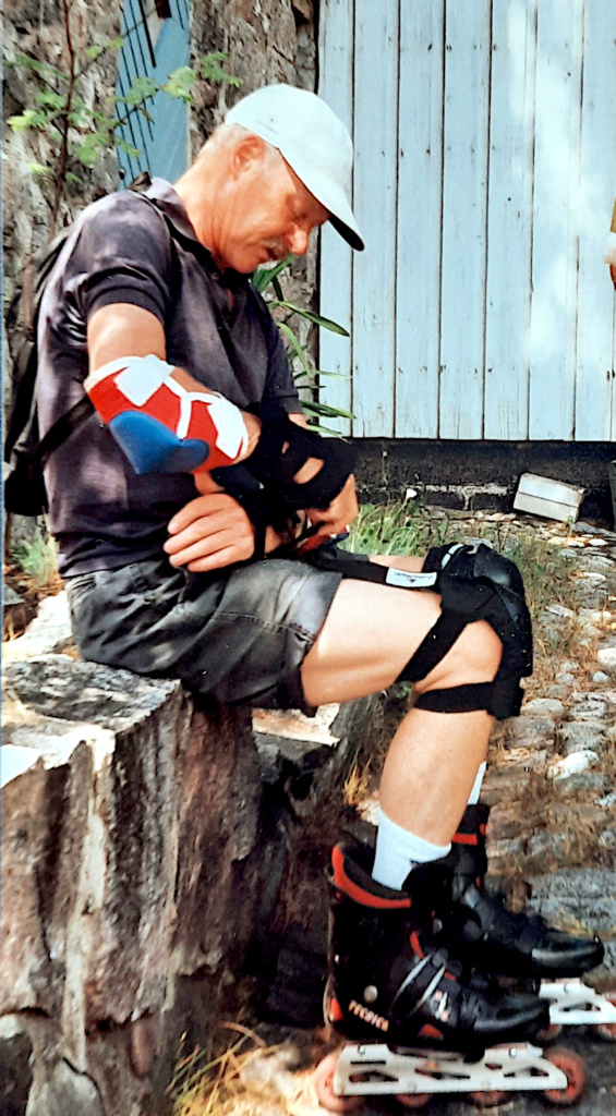 Mies pukee rullaluistelusuojia käsiinsä.