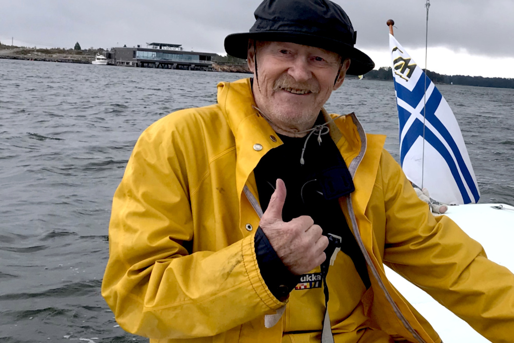 Mies tyytyväisenä purjeveneen ohjaimissa.