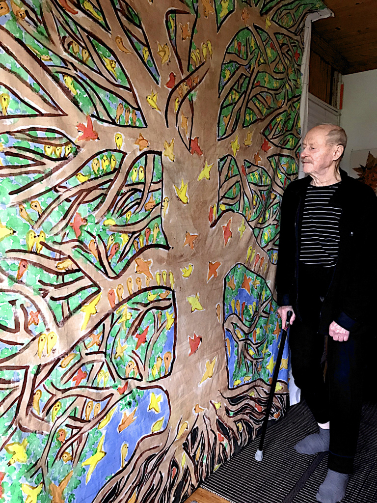 Vanha mies katsoo seinävaatteen puuta.