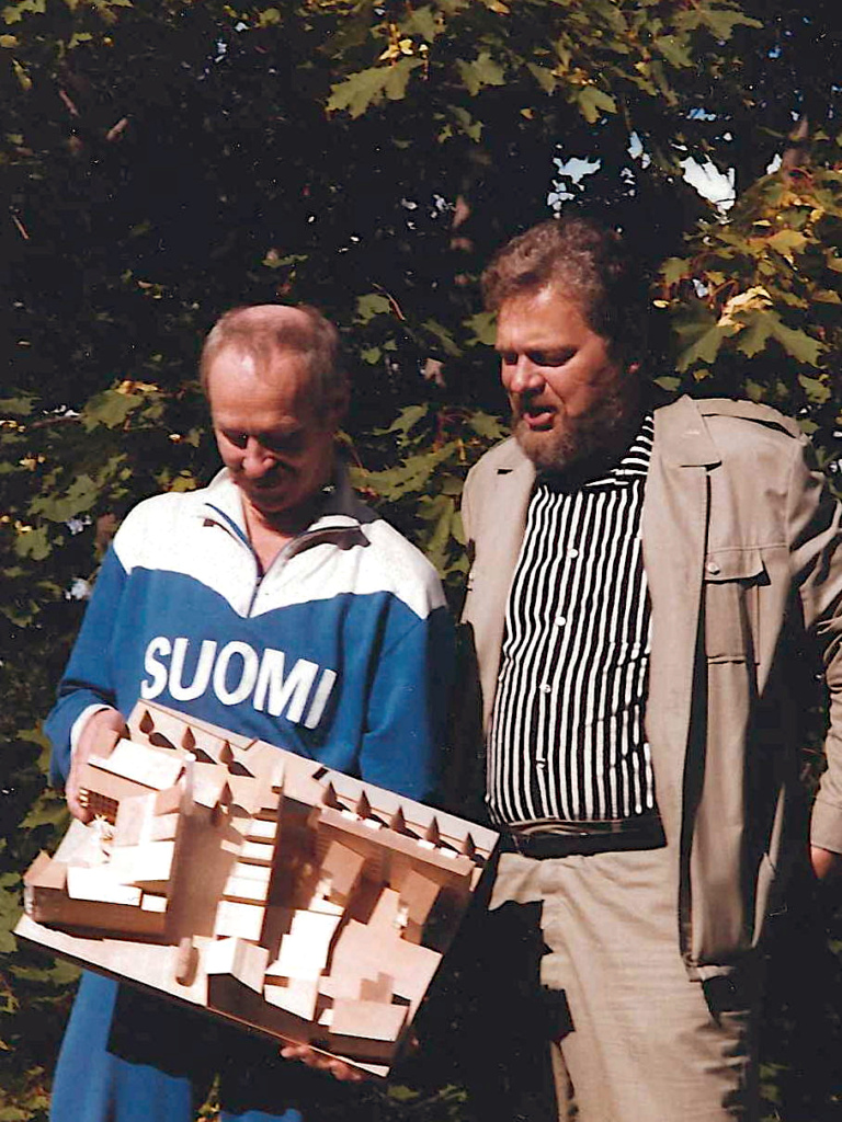 Kaksi arkkitehtia pienoismalli käsissään.