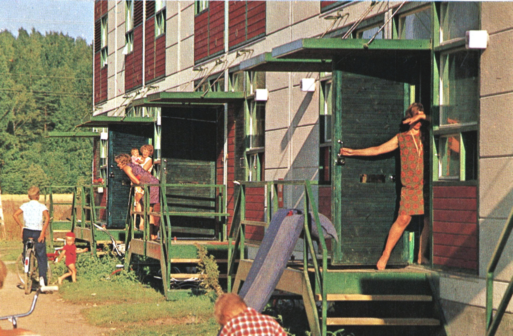 Ihmisiä modernin rivitalon ovilla.