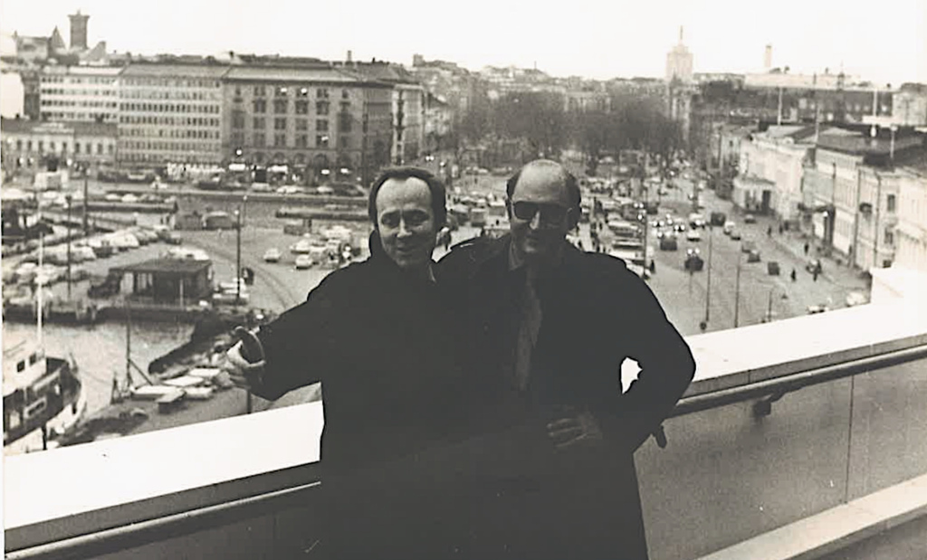 Kaksi miestä kattoparvella, taustalla Helsingin Kauppatori.