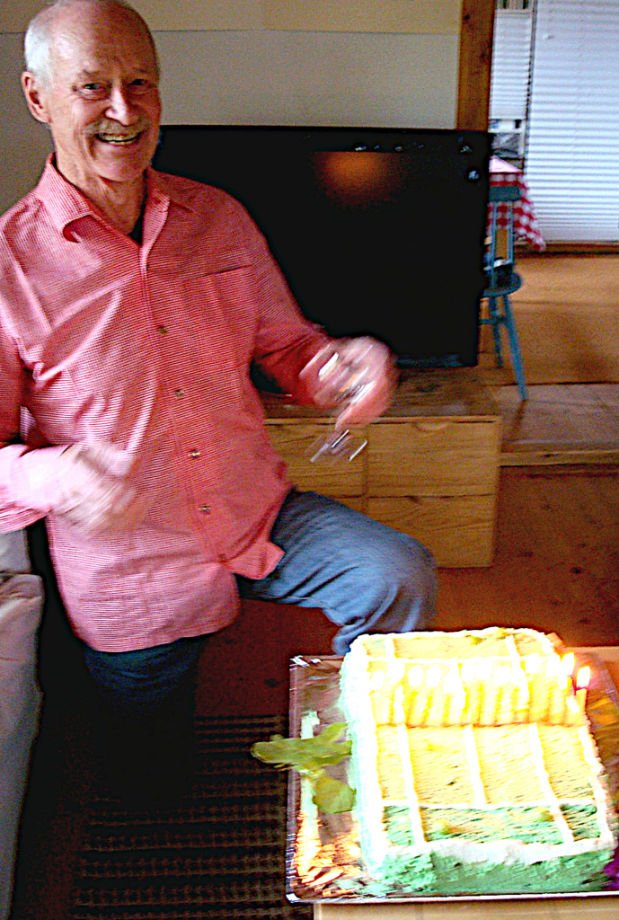 Mies esittelee tenniskentän muotoista kakkua.